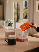The traditional stoneware mug on a table beside a box of Coffeeangel brew bags